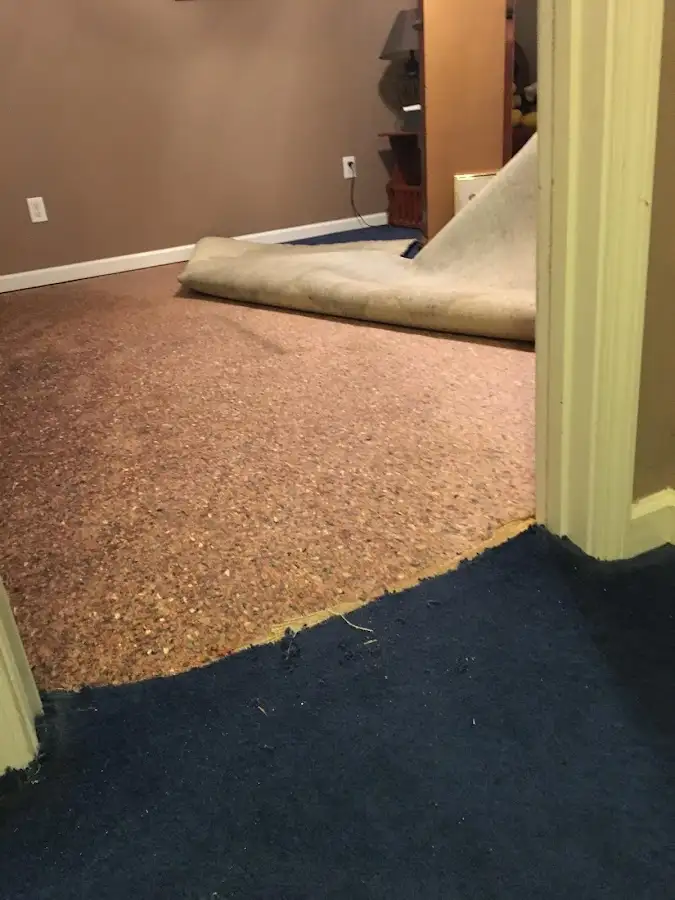 Carpet pad removal revealing water damage during Water Mitigation Services in Enid